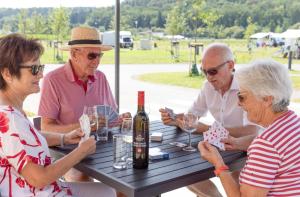 a group of people sitting at a picnic table with wine glasses at Camping Resort Riegersburg in Riegersburg