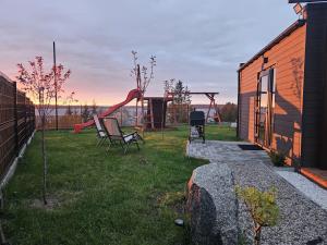 a playground with a slide in a yard at Domek nad jeziorem in Kruklanki