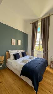 a large bed in a bedroom with a large window at Hospice St Nicolas in Troyes