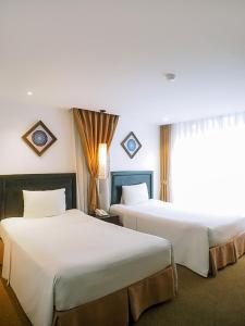 Postel nebo postele na pokoji v ubytování Rosa Hanoi Hotel