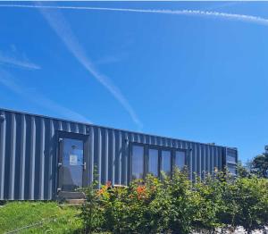 a black building with a door and some plants at Le DiamanSter Francorchamps in Stavelot