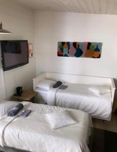a room with three beds and a flat screen tv at Moderni rantasauna ja -mökki in Joensuu