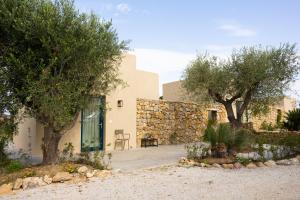 a house with a stone wall and trees at Resort Fontes Episcopi in Aragona