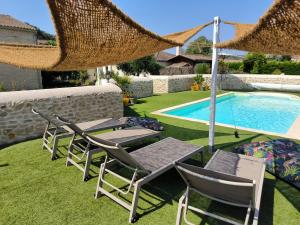 eine Gruppe von Liegestühlen und einem Pool in der Unterkunft LES BOHEMIELLES 4**** Cottage MARTIN in Cartelègue