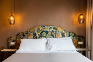 a bedroom with a large bed with a floral headboard at Resort Fontes Episcopi in Aragona