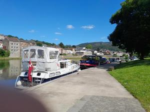 a boat is docked at a dock on a river at Gite chez carole in Monthermé