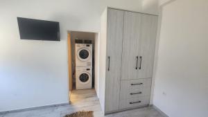 a laundry room with a washer and dryer next to a closet at Klimis apartments in Sifnos