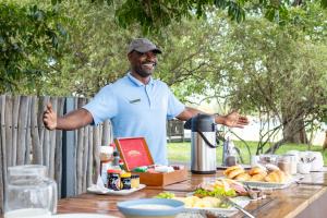 a man standing in front of a table with food at Chundu Island in Victoria Falls