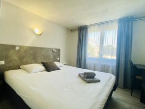 a bedroom with a bed with a hat on it at Auberge de Lamagistere in Lamagistère +39 photos