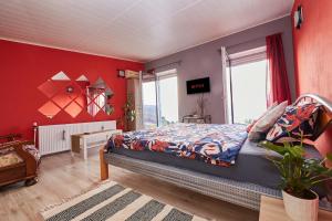 a bedroom with a bed and a red wall at Banat Residence in Reşiţa