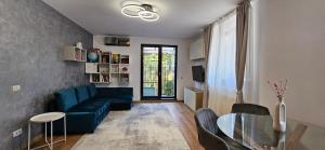 a living room with a blue couch and a glass table at Exclusive Living Apartment in Bucharest