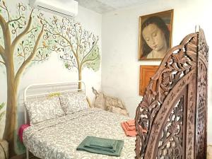 a bedroom with a bed with a tree mural on the wall at Quinta do Castelo, Casa de Campo de Pedra in Reguengo Grande