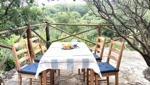 a table and chairs with a bowl of fruit on it at Quinta do Castelo, Casa de Campo de Pedra in Reguengo Grande