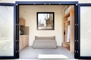 a room with a bed and a sliding glass door at wecamp Cudillero in El Pito