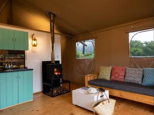 a living room with a couch and a stove at AfriCamps at Milorho in Rustenburg