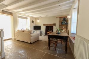 a living room with a table and a couch and a table at North View cottage. Shaldon village. in Shaldon