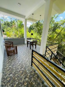 a screened in porch with a table and chairs at Dhanudi Homestay in Ella