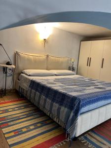 una camera da letto con un letto con una coperta blu e bianca di Monolocale Castello Cagliari centro storico a Cagliari
