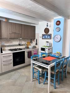 una cucina con tavolo, sedie e fornelli di Monolocale Castello Cagliari centro storico a Cagliari