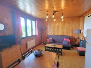 a living room with a couch and a table at Appartement au RDC d'un Chalet - Proche Ski/Randonnées - Terrasse Sud - 4 pers - FR-1-393-150 in Saint-Michel-de-Chaillol
