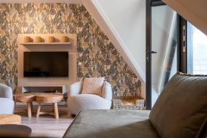 a living room with a fireplace and a tv at Hello Zeeland - Appartement Duno Lodges 6 personen in Oostkapelle