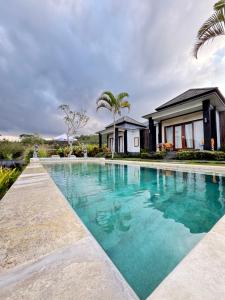 an image of a swimming pool in front of a house at Bali Astetic Villa and Hot Spring in Kintamani