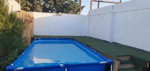 a blue swimming pool in a backyard with a fence at GoldenPirshaghi in Pirşağı
