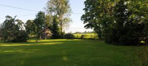 a large green yard with a cabin in the background at Kenni Holiday House in Kenni