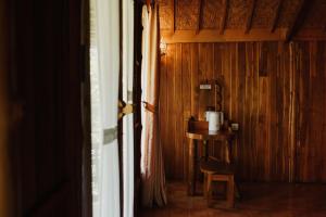 a room with a table and a chair next to a door at The Tamban Jukung in Nusa Penida +22 photos