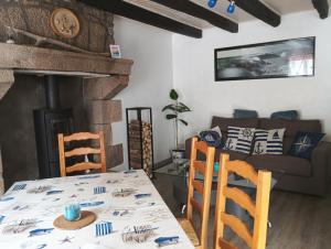 a living room with a table and a couch at Maison de vacances in Languidic