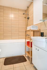 a bathroom with a white tub and a sink at Bella Jūrmala ApartHotel in Jūrmala