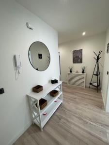 Habitación blanca con espejo y estante en Hogar Ribeiriña Ribeira, en Ribeira