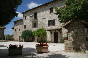 a stone building with two pots of flowers in front of it at Country House Carfagna in Assisi