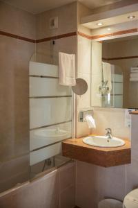 a bathroom with a sink and a mirror at Kyriad N&icirc;mes Ouest A9 in N&icirc;mes