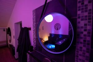 La GuérinièreにあるL'échappée nocturne Loveの紫色の部屋にある丸い鏡のあるバスルーム
