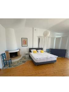 a bedroom with a bed and a fireplace at Villa Caretta - direkt an einem einsamen Strand im Süden des Peloponnes in Áyioi Taxiárkhai