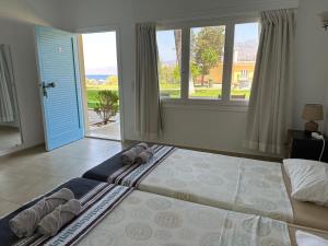 a bedroom with a large bed and a large window at Bouros Seaview Farm in Karistos