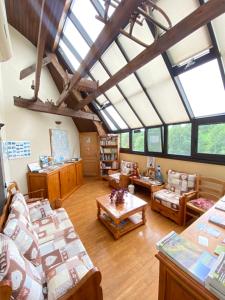 una gran sala de estar con muchas ventanas en Logis Hôtel Restaurant Auberge du Bougnat, en St Victor la Riviere