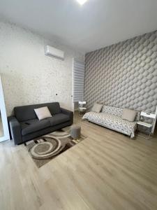 a living room with a black couch and a rug at Catapano's House in Pompei