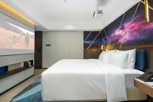 Rúm í herbergi á Mehood Lestie Hotel Maoming High-speed Railway
