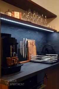 a kitchen counter with a shelf with utensils on it at Deer Apartment - exclusive apartment Jihlava in Jihlava
