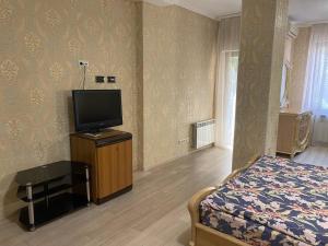 a bedroom with a bed and a flat screen tv at Valencia Hotel in Odesa
