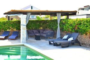 een patio met blauwe stoelen en een zwembad bij Guest house Damir in Ražanac