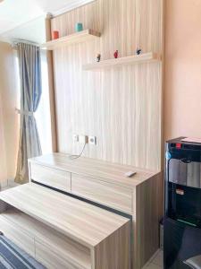 cocina con estanterías de madera y cafetera en 1 BR Apartment at BSD City by Miapato, en Tangerang