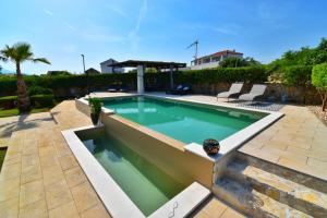 een zwembad in een tuin met een patio bij Guest house Damir in Ražanac