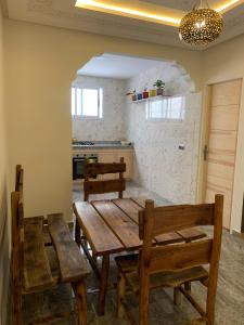 a dining room with a wooden table and chairs at Dar sirin in Essaouira +10 photos
