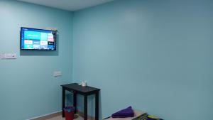 a room with a tv on a blue wall at Nilai H2 in Nilai +13 photos