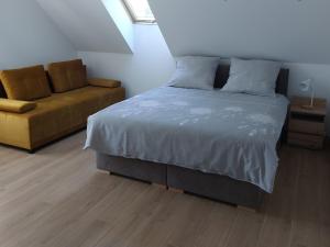 a bedroom with a bed and a couch at Domki, pokoje, apartamenty Agata Kunowska in Ostrzyce