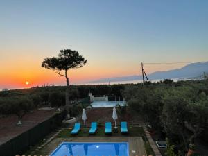 a swimming pool with a sunset in the background at Zorbas Suites in Hersonissos