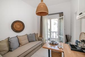 een woonkamer met een bank en een tafel bij Anemis in Tinos Town +40 foto's